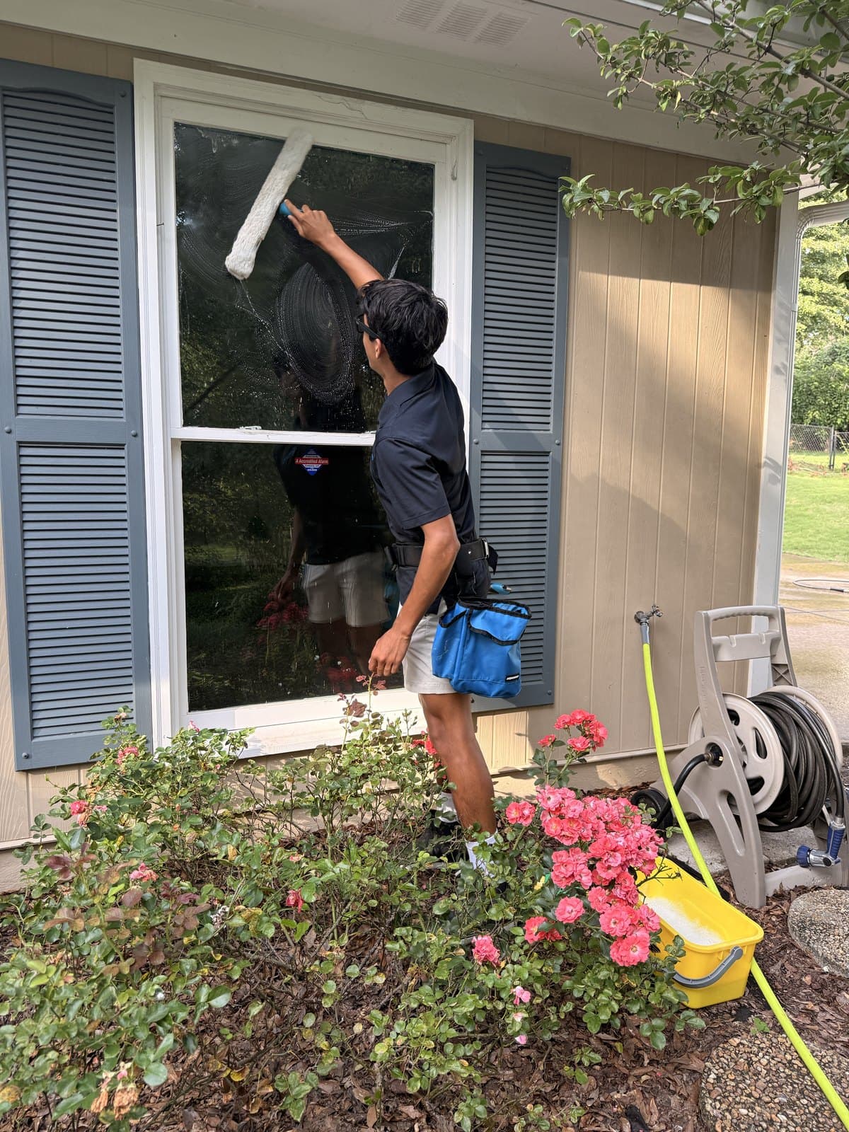 Team Clean technician washing an exterior window with a T-bar washer in the Columbus, GA area
