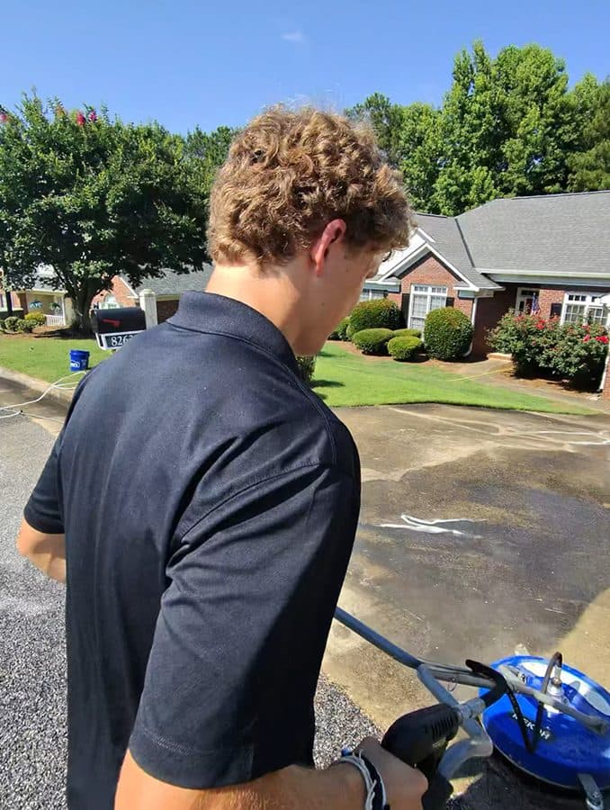 Team Clean running a surface cleaner on a driveway in the Columbus GA area